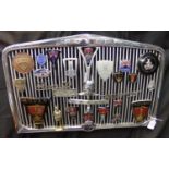 Rover 90 post war radiator grill, mounted with a varied collection of assorted Rover vehicle badges.