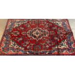 Red ground washed Persian Saruk village rug, with central foliate medallion. 245 x 159cm approx. (