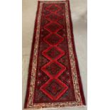 Multi-coloured ground Persian runner with seven repeating lozenge medallions. (B.P. 21% + VAT)