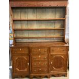 Early 19th century oak North Wales two stage dresser, the moulded cornice boarded rack with fitted