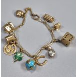 9ct gold charm bracelet with assorted charms including: dice, globe, heart, cottage, bus, bulls's