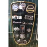 Datsun/Nissan radiator grill set with various Datsun and Nissan vehicle badges, assorted.