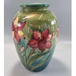 Mid century Moorcroft pottery tube lined 'African Lily' vase on a green ground, of baluster form,