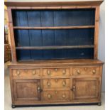 Early 19th century oak North Wales two stage dresser, the moulded cornice above stained boarded rack