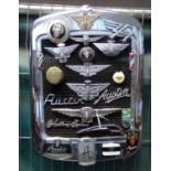 Pre War Austin radiator grill set with various pre and post War Austin motorcar badges and insignia.