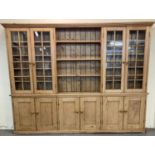 Early 20th century pine Library bookcase, the moulded cornice above an arrangement of four glazed