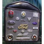 Vintage Model T Ford radiator grill set with various Ford vehicle badges, including: Ford V8, Script