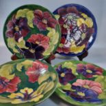 Three Moorcroft pottery tube lined plates, together with a Moorcroft tube lined bowl decorated in '