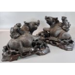 Pair of Japanese carved hardwood studies of Water Buffalo with children on their backs, having