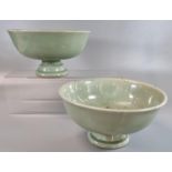 A pair of oriental celadon glazed heavily potted porcelain stem bowls. Impressed marks to bases