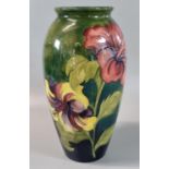 Moorcroft pottery tube lined green ground Hibiscus vase of ovoid form. Impressed and painted
