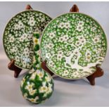 Pair of Chinese export porcelain shallow dishes, decorated with prunus blossom on a green enamel