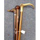 Three walking sticks to include: duck's head, antler and simulated amber knops. (3) (B.P. 21% + VAT)