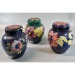 Three Moorcroft pottery tube lined ginger jars and covers, Hibiscus and other designs. (3) (B.P. 21%