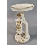 Royal Worcester figure of a girl in the Kate Greenaway style, holding a basket and standing under