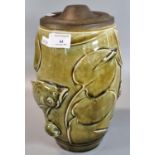 Studio Art pottery barrel shaped green glazed lamp base with gilt metal lid, overall with relief