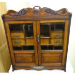 Early 20th century oak two door glazed presentation smokers cabinet with key, the silver plaque