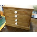 Small tabletop pine four drawer coin/specimen cabinet with ceramic knob handles. 41x50x33cm