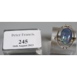 Oval triplet opal ring set within an open setting with six diamonds in platinum fronted yellow