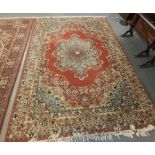 Large Persian design carpet on a salmon ground with multi-coloured flowers and foliage. 253x352cm
