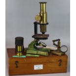 Early 20th Century French brass microscope in fitted case with accessories including glass