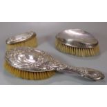 Three silver ladies vanity repoussé and other brushes. (B.P. 21% + VAT)