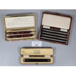 Amber cheroot holder with gold band within fitted case, a cased Conway Stewart writing set