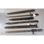 Two Remington US bayonets with scabbards together with another, probably German with wooden grip and