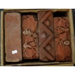 Box containing four Victorian bricks, three with moulded design; two vine leaf and grape and one