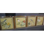 Set of four Japanese printed panels on fabric depicting birds amongst blossom. 46x45cm approx.