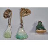 Two jade pendants on chains and another similar yellow metal mounded in the form of a Buddha. (3) (