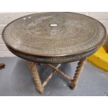 Indian brass topped table on folding barley-twist turned wooden base. (B.P. 21% + VAT)