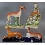 Two Staffordshire Pottery seated Greyhounds, one standing carrying a rabbit and a spill vase with