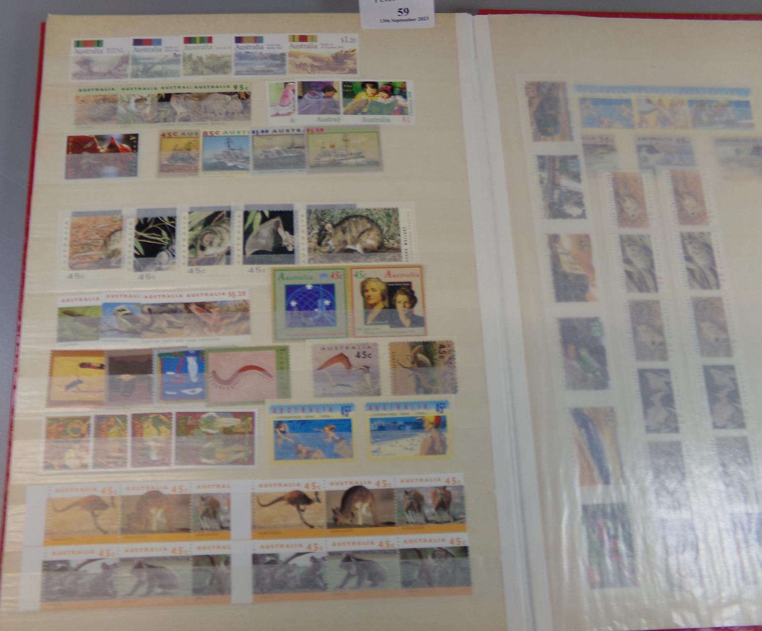 Red stock book of Australia and Canada U/M mint stamps of Queen Elizabeth 1950's to 1990's. 700 +