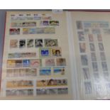 Red stock book of Australia and Canada U/M mint stamps of Queen Elizabeth 1950's to 1990's. 700 +