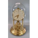 Kern German made brass perpetual motion dome clock, with glass dome. Overall 31.5cm high approx. (