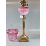 Early 20th century double oil burner lamp having cranberry glass shade above a pink opaline glass