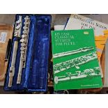 Cased Beuscher flute with various music books.'