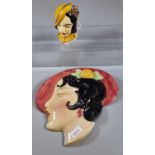 Art Deco ceramic wall plaque/mask of a lady with hat, together with another Art Deco ceramic lady