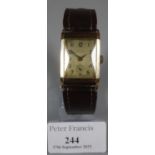 9ct gold rectangular gent's wristwatch with leather strap, the face indistinctly marked. (B.P. 21% +