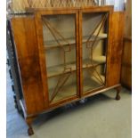 Art Deco design veneered walnut two door display cabinet, the interior revealing fitted shelves