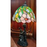 Modern Tiffany style table lamp, the base with bronzed decoration of Victorian gent and lady with