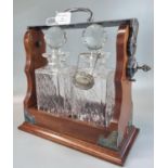Victorian style mahogany and chrome tantalus comprising two crystal square section decanters with
