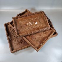 Set of three graduated two handled, probably Indian carved foliate trays of rectangular form. (B.