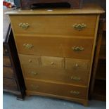 Modern oak chest of drawers having an arrangement of four long and three small drawers with brass