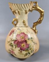 Royal Worcester blush ivory baluster shaped jug with floral decoration and gilded crab-stock handle.
