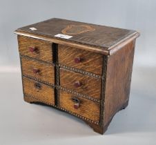 Unusual oak miniature straight front chest of six drawers on bracket feet with central armorial to