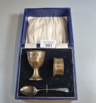 Silver christening set in original box comprising: napkin ring, egg cup and spoon. Birmingham