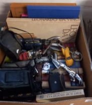 Box of assorted old books, Jaguar car mascot, odd diecast toys, miniature binoculars, wicker