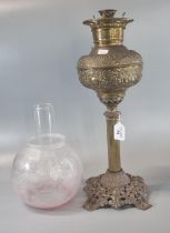 Early 20th Century oil burner lamp, having etched globular shade above a brass repousse reservoir on